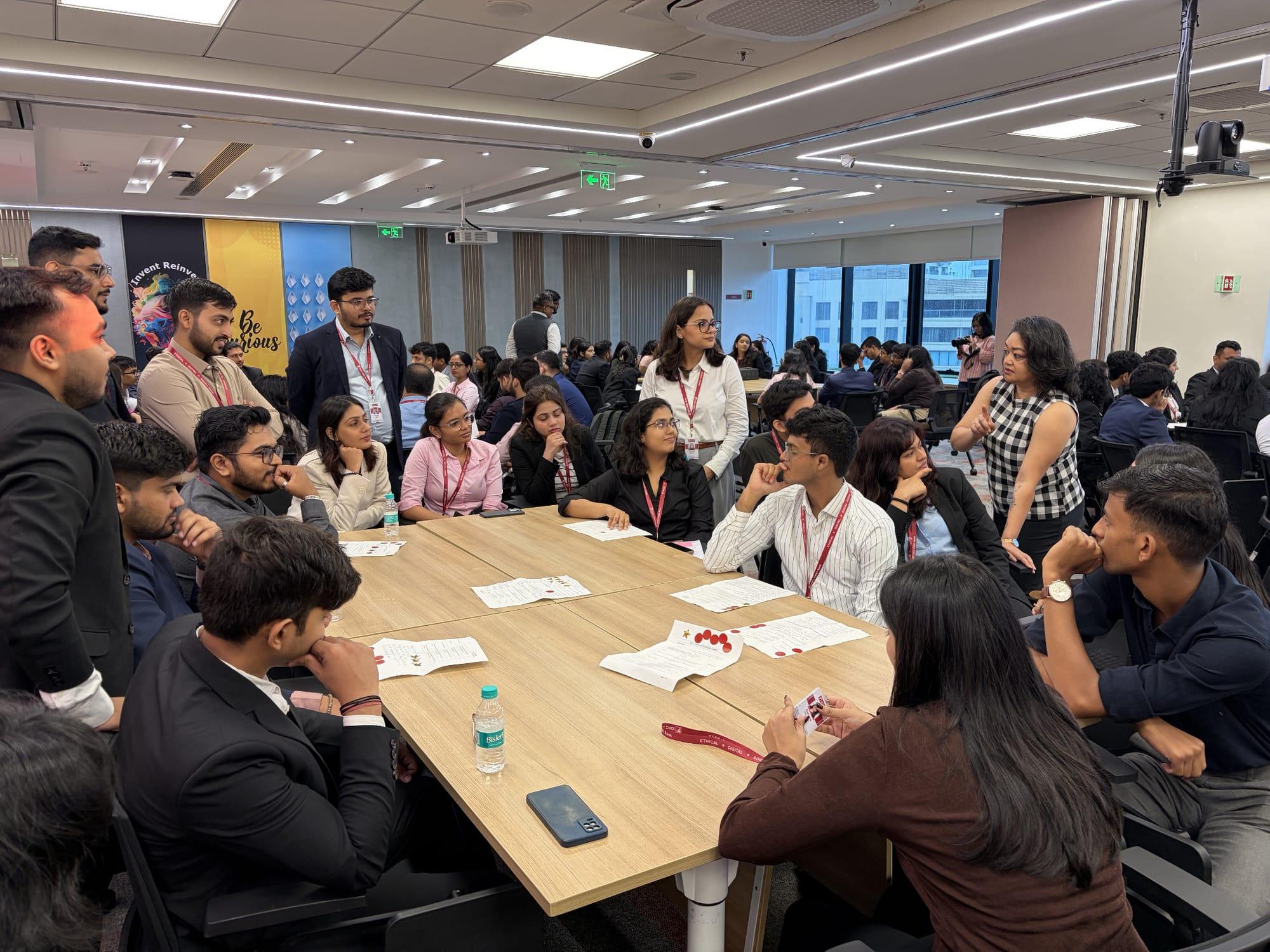 Participants working through an exercise at their tables while a facilitator guides them
